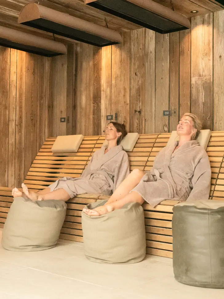 2 women relaxing on infrared loungers for detoxification