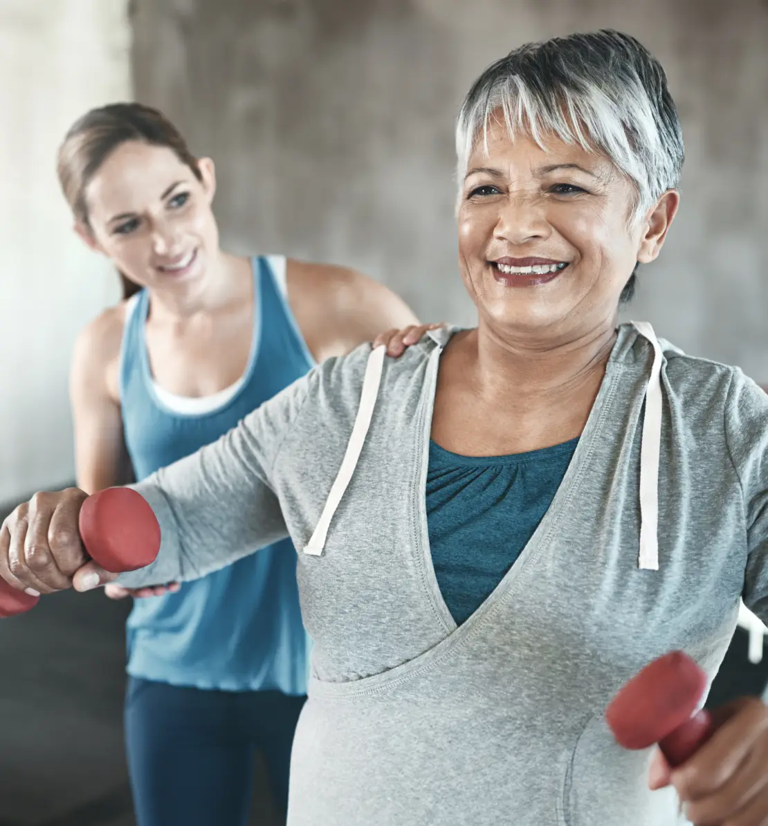 Women doing weights with personal trainer