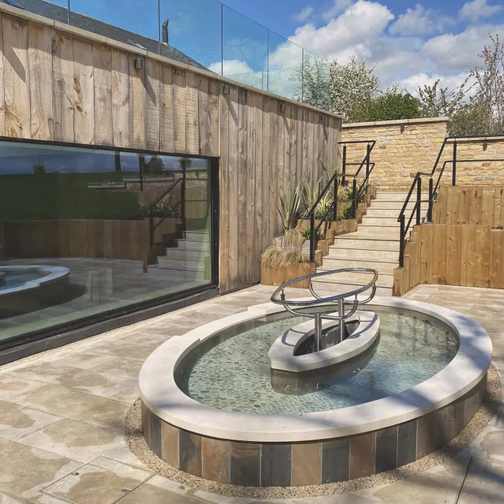 Outdoor spa bathing experience within the spa garden, offering warm water and a calm, restorative setting.