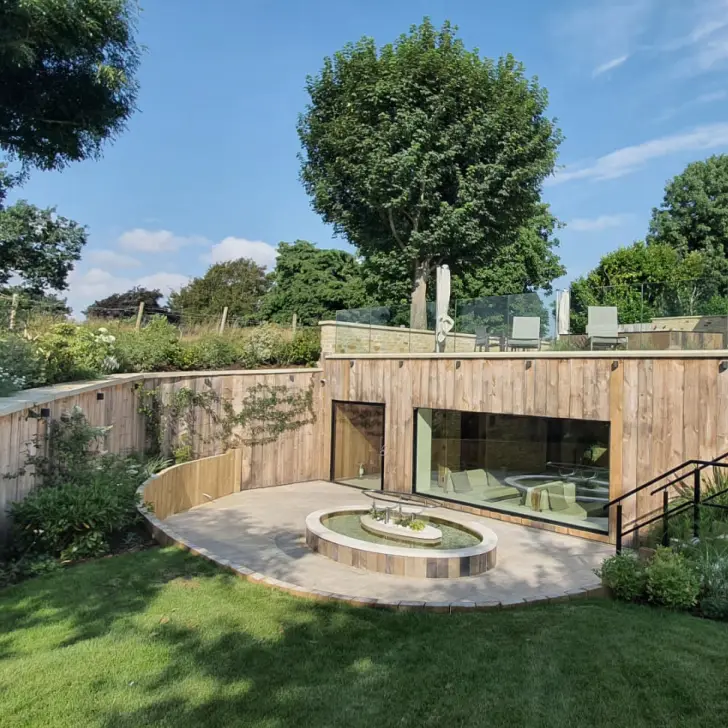 Spa garden with outdoor bathing features and open countryside views, supporting rest and relaxation during a Living Well Spa visit.